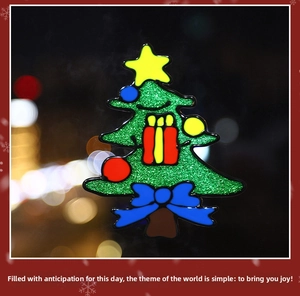 Close-up of glittery green enamel Christmas tree brooch with colorful gift box ornaments