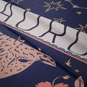 Close-up detail of soft zodiac tapestry fabric featuring golden stars and blue patterns