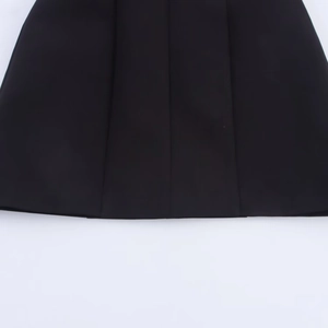 Gros plan de l'ourlet noir d'une mini robe à licou avec détail de nœud papillon