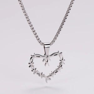 Macro shot of silver heart pendant with thorn texture and polished box chain link