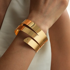 Macro shot of tiered gold metallic spiral cuff bracelet with a polished glossy finish