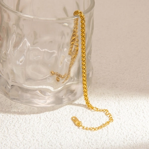 Detail of 18k gold plated wheat chain bracelet on textured glass with extension chain