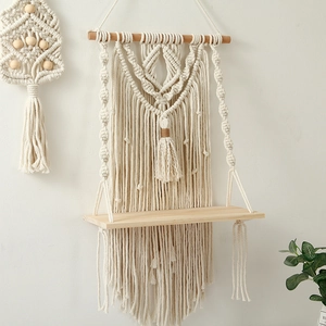 Detail of bohemian hand-woven cotton rope wall shelf with natural wooden board