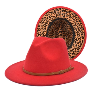 Detail of red fedora hat featuring leopard print brim and studded leather belt buckle