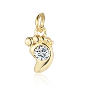Macro view of gold-plated foot-shaped copper pendant with sparkling clear zircon stone