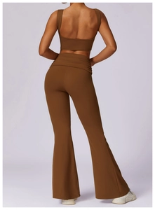 Detail of high-support yoga sports bra with open back and flared pants in brown