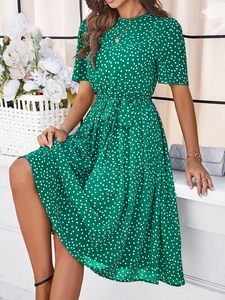 Détail d'une robe midi verte à pois avec ceinture assortie sur un balcon ensoleillé
