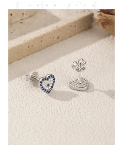Detailed macro view of 925 sterling silver heart studs with blue and white zircon pavé