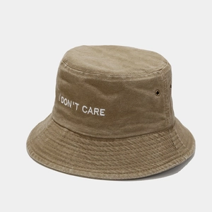 Close-up of I DON'T CARE embroidery on khaki washed cotton fisherman hat with metal eyelets