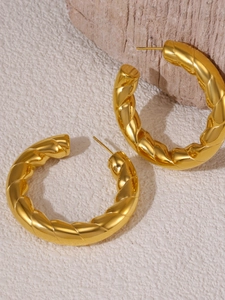 Macro shot of 18K gold plated twisted C-shape hoop earrings with classic French vintage texture