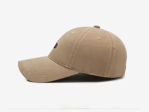 Dettaglio del cappellino in cotone kaki con ricamo laterale blu e cuciture rifinite