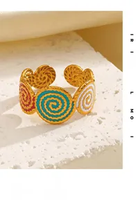 Macro view of gold-plated open ring featuring red, blue, and white enamel spiral patterns
