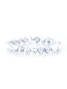 Detailed view of white marble beads on an elastic bracelet with clear reflections