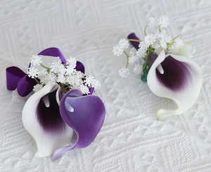 Detail of calla lily boutonniere in purple gradient with silk ribbons and gypsophila