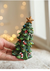 Close-up of a hand-held mini resin Christmas tree with colorful painted decorations