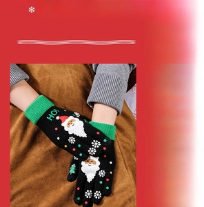 Detail of Christmas knitted gloves featuring Santa Claus embroidery and warm winter texture