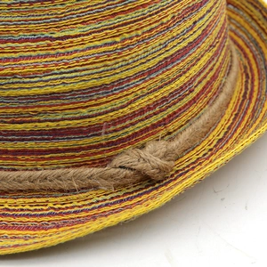 Macro detail of colorful woven straw hat with rustic hemp rope trim and bohemian knot
