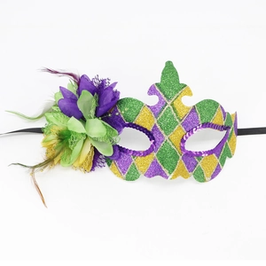 Close-up of Masquerade mask with purple feathers, green flowers and gold sequins