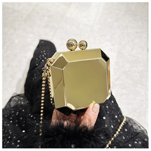 Detailed view of a gold geometric octagonal evening clutch bag with round ball clasp