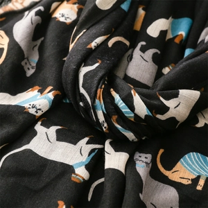 Close-up of the black cotton linen scarf showing soft texture and cute cartoon cat prints
