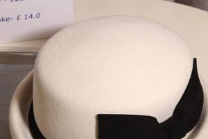 Detail of elegant wool felt hat with decorative black ribbon bow and textured surface