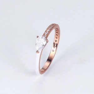 Detailed close-up of pear-cut gemstone ring with rose gold and white enamel accents