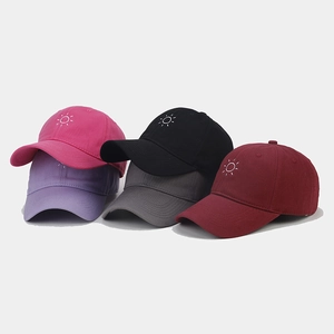 Detailed close-up of sun embroidery on various colored cotton baseball caps