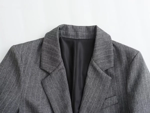 Detail of grey pinstripe wool blend blazer featuring notched lapels and smooth black lining