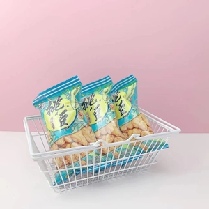 Mini white iron wire storage basket with snacks shown on a soft pink background
