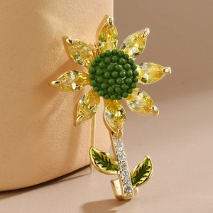 Close-up of a golden sunflower brooch with yellow faceted stones and green bead center