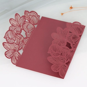 Macro shot of laser-cut red rose floral pattern on wedding invitation cover