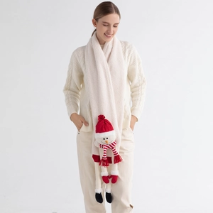 Detail of knit beige scarf featuring a cute snowman doll with red hat for Christmas