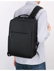 Male model wearing the black business laptop backpack with integrated USB charging port
