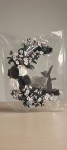 Close-up of crescent moon cat wreath with black and white roses and integrated LED light