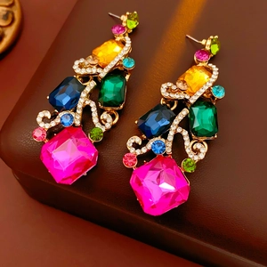 Macro detail of vintage square earrings with colorful gemstones and gold metal base