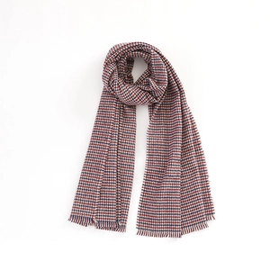 Detail of red and blue houndstooth scarf with classic fringes on white background