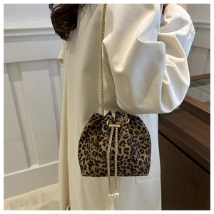 Detail of leopard print bucket bag featuring gold chain strap and pearl drawstring charms