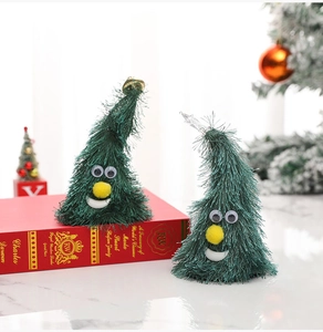 Détail de deux sapins de Noël en peluche avec des yeux mobiles pour décor de fête
