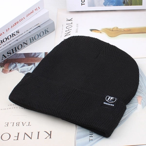 Detailed knit texture of a black winter beanie featuring a stylish woven patch label