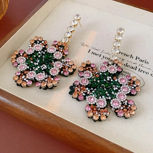 Detailansicht bunter Strass-Ohrhänger in Blumenform mit funkelndem Finish