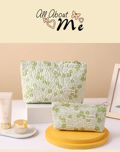 Detail of floral linen makeup bags with textured plant embroidery and metal zipper