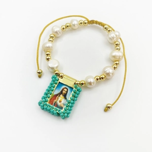Detailed view of a vintage religious bracelet with natural pearls and a Jesus pendant