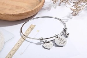 Macro view of adjustable steel wire bracelet with Love Grandma heart charms and scale measurement