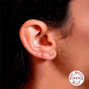 Three gold starfish S925 sterling silver stud earrings set shown on model ear