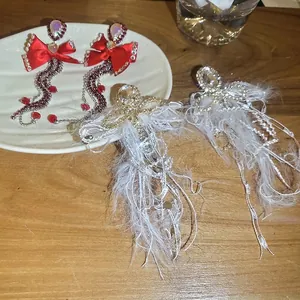 Elegant bow and feather tassel earrings with sparkling rhinestones in a stylish pair
