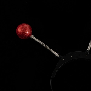 Detail of red glitter eyeball headband with silver spring and integrated battery box