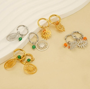 Detail of bohemian evil eye earrings with sunburst charms and colored beads in gold and silver