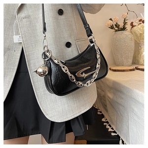 Close-up of black pleated faux leather underarm bag with silver chain and star logo