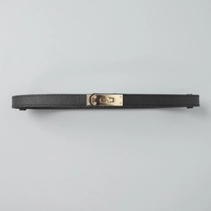 Detail of black pebbled leather belt featuring a gold-toned metal twist-lock buckle
