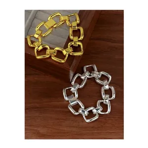 Polished thick gold and silver chain link bracelets shown on a wooden jewelry display stand